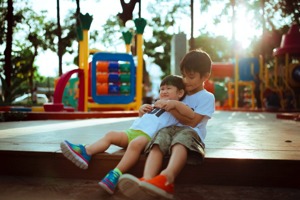 Two young people hugging on a playground