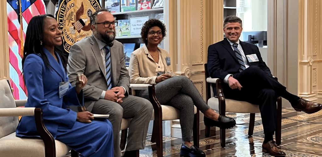 A three-person panel and moderator seated in the White House Library.