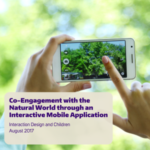 A person uses a cell phone to take pictures of leaves on a tree