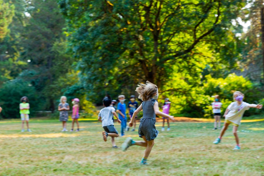 A group of children playing outdoors at summer camp