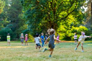 A group of children playing outdoors at summer camp