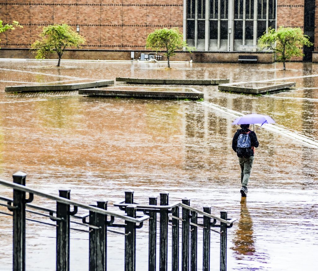 A student walking in the rain on the University of Washington, Seattle campus