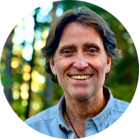 A picture of Philip smiling in front of a forest