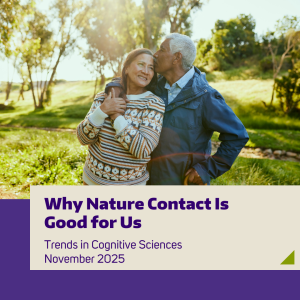 Two older adults embraced in a hug while in a park