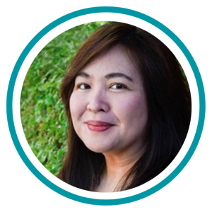 A headshot of Aileen with a slight smile in front of a hedge