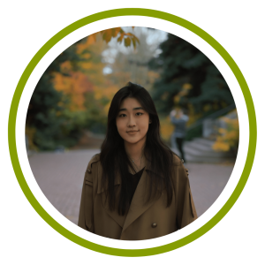 Yuxuan stands in front of trees with fall colors