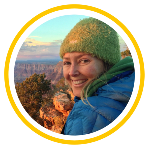 A headshot of Courtney Aber smiling. A canyon is in the background.