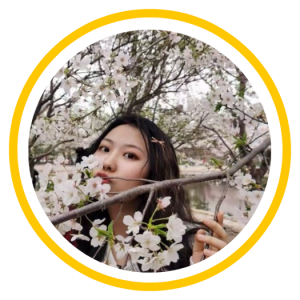 Jingjing (Tina) Tao poses behind cherry blossoms