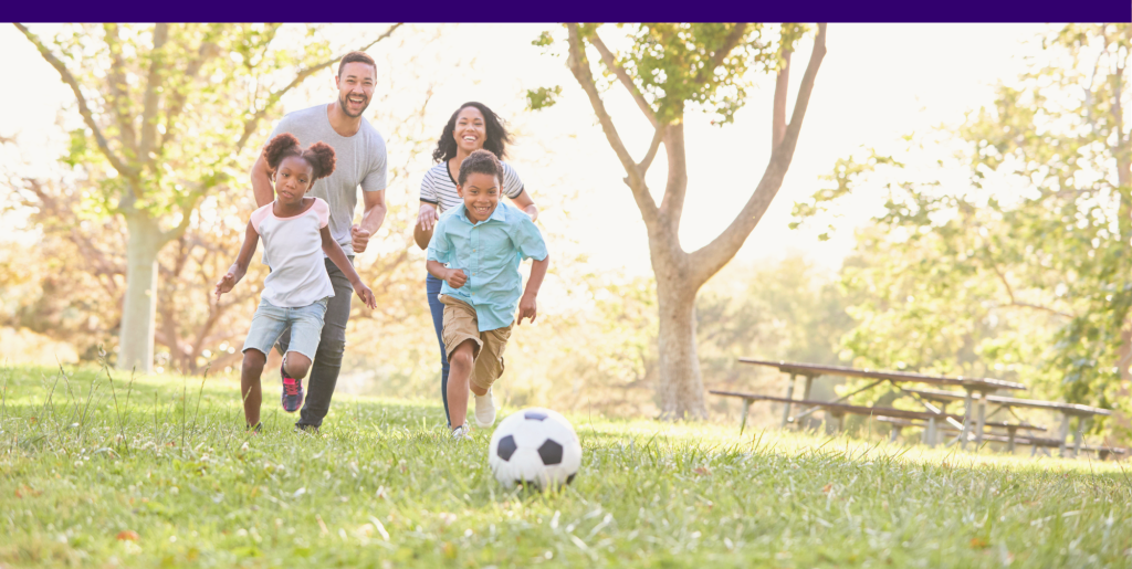 A family with young kids playing soccer