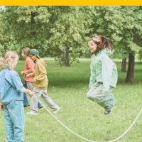 Children jumping rope in a park filled with trees