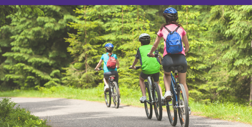 Three children biking in a tree-lined park