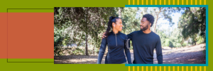 Two people walking in the forest. One has their arm around the other's shoulders.