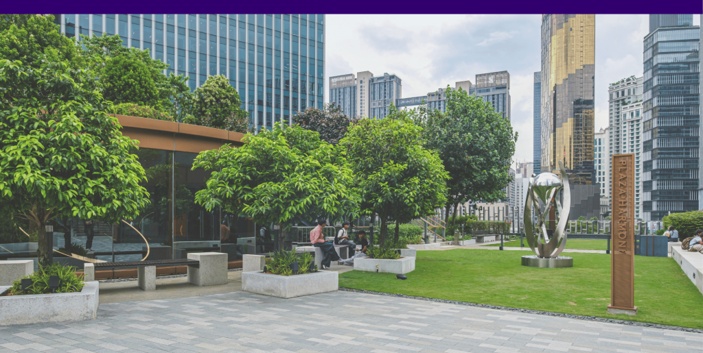 A small urban park with a grassy field and trees